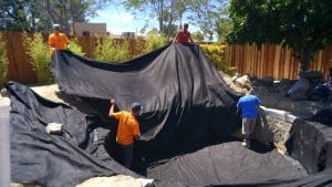 Black,Pond,Liner,Being,Laid,In,A,Dug,Hole.,Pond